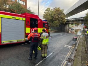 Fire service rescue woman trapped in car on flooded road