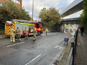 Fire service rescue woman trapped in car on flooded road