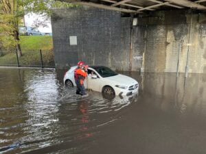 Fire service rescue woman trapped in car on flooded road