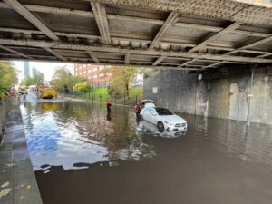 Fire service rescue woman trapped in car on flooded road