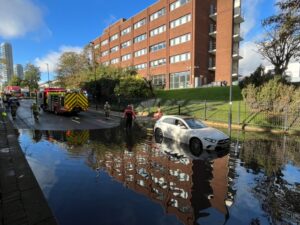 Fire service rescue woman trapped in car on flooded road