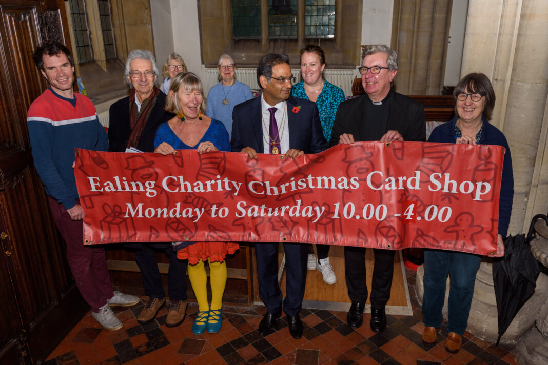 Volunteers at the opening of the Ealing Charity Christmas Shop with Sue Green, founder (fourth from left); Ealing’s Immediate Past Mayor, Councillor Munir Ahmed (centre); and Father Richard Collins, Vicar of Parish Church of Christ the Saviour (second from right) which is where Card Shop will be open 10am-4pm until 18 December 2022.