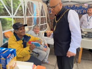 Mayor of Ealing, Councillor Hitesh Tailor with local people at pop up soup kitchen at Clayponds